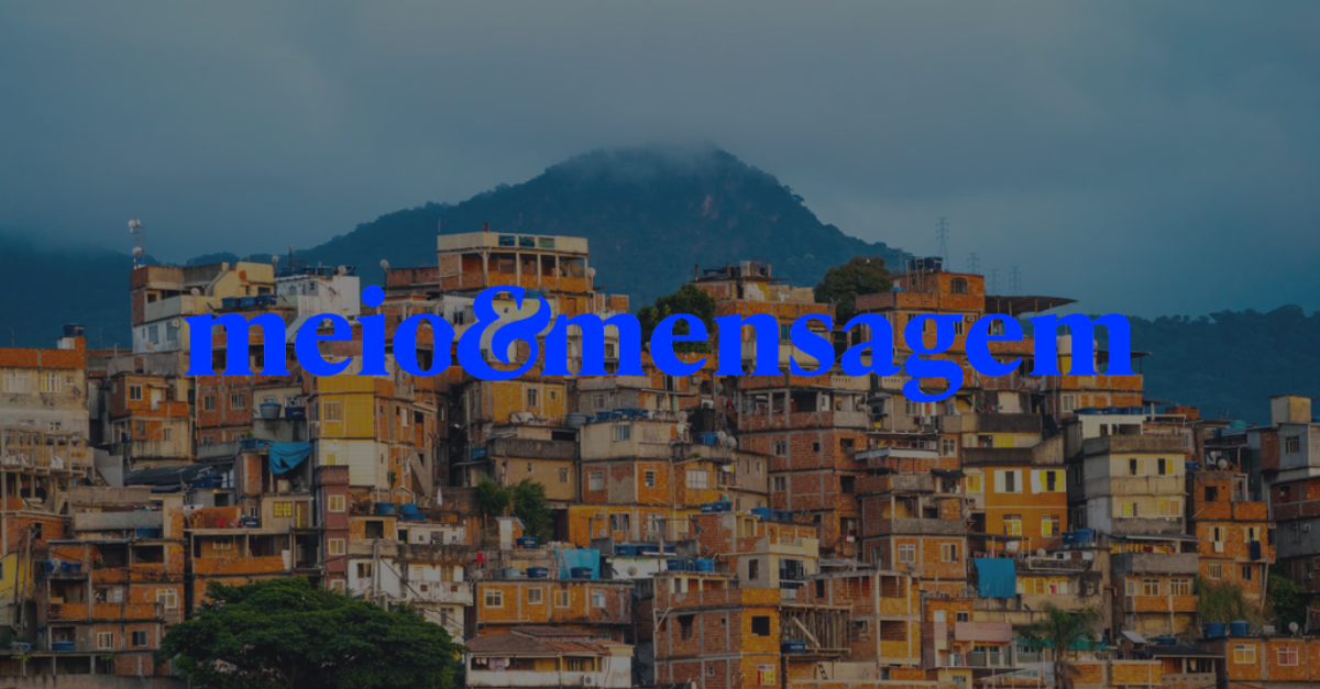 Vista de comunidade com casas coloridas empilhadas em morro, com logotipo "meio & mensagem" sobreposto em azul